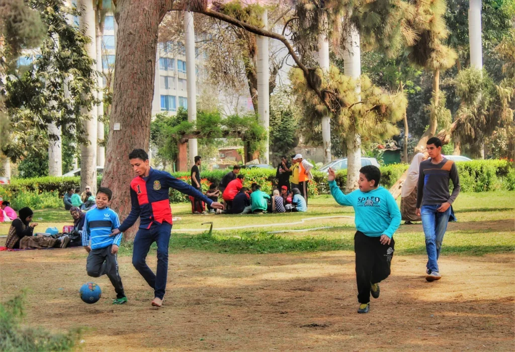 أطفال يلعبون كرة القدم في ملعب